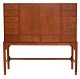 Chest of drawers designed by Knud Juul Hansen, crafted in teak. The piece features a total of 14 drawers and two doors at the front, concealing additional storage space. H: 160 cm.W: 160cm. D: 50cm