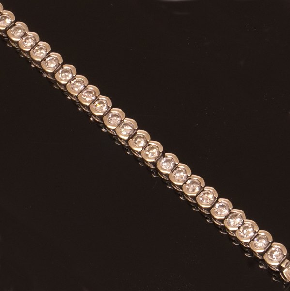 14kt hvidguld tennisarmbånd prydet med 62 diamanter på hver ca. 0,05ct i alt ca. 
3ct. L: 19,5cm. B: 4mm. V: 15gr