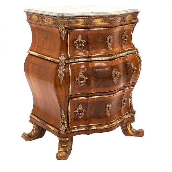 Signeret Ortmann kommode i nødde- og nødderodsfinér med marmorplade. Prydet med forgyldninger og forsølvinger. Mathias Ortmann Købehavn ca. år 1750. H: 81,5cm. B midt: 64cm. B fod: 74cm. D: 48cm
